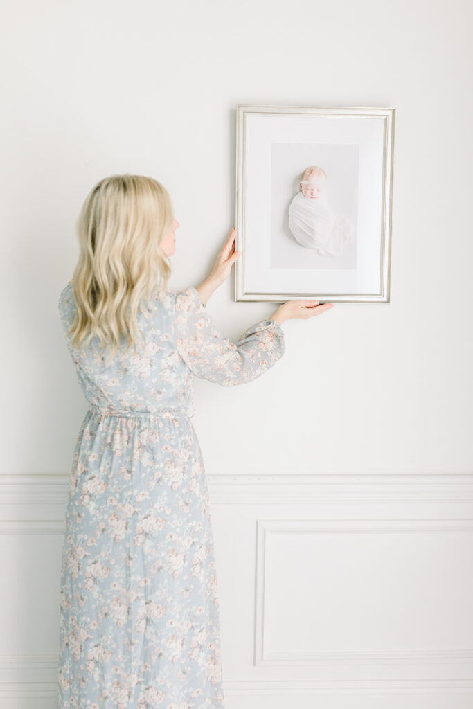 Brandon newborn photographer | Ashley from CJ and Olive Photography hanging beautiful newborn frame on wall. 