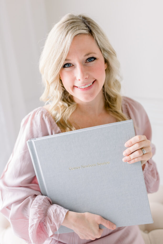 Brandon newborn photographer | Ashley from CJ and Olive Photography holding heirloom family album. 