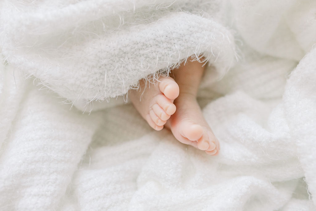 Newborn baby boy swaddled with feet showing and close up on baby's feet for a detail shot in the studio. Image taken by Brandon newborn photographer, CJ and Olive Photography. 