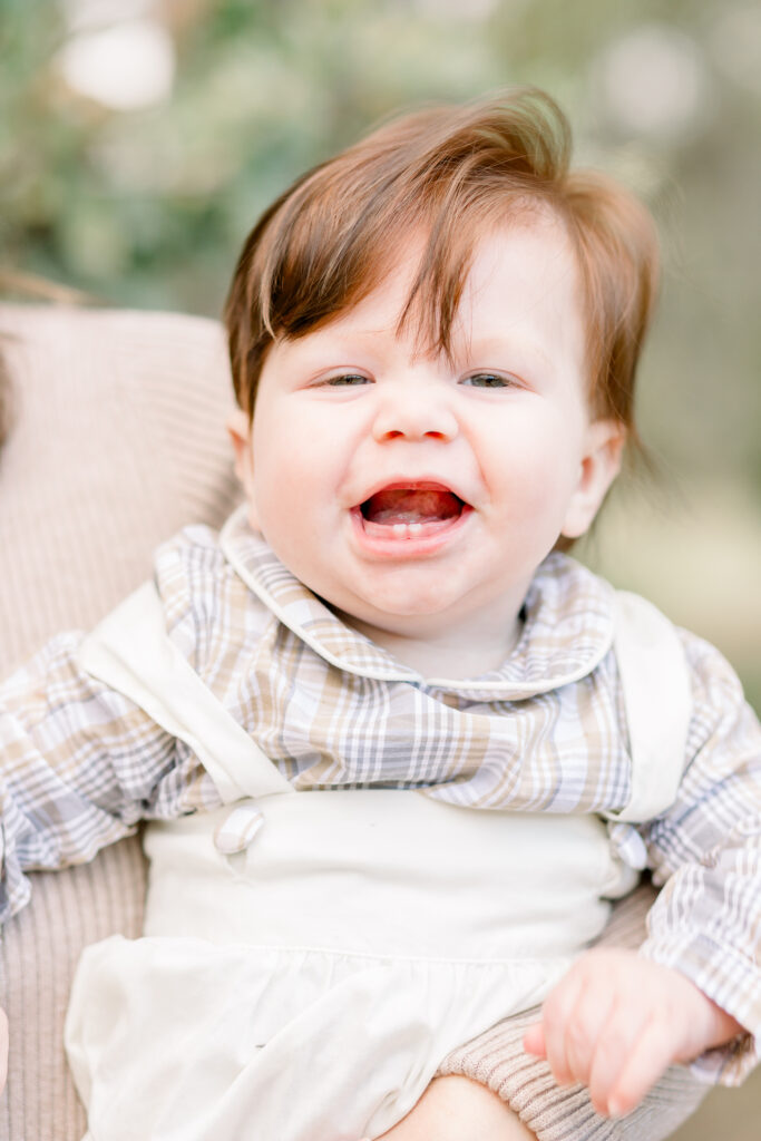 Little boy smiles at camera for fall family photos. Image captured by Flora, Mississippi photographer, CJ and Olive Photography. 