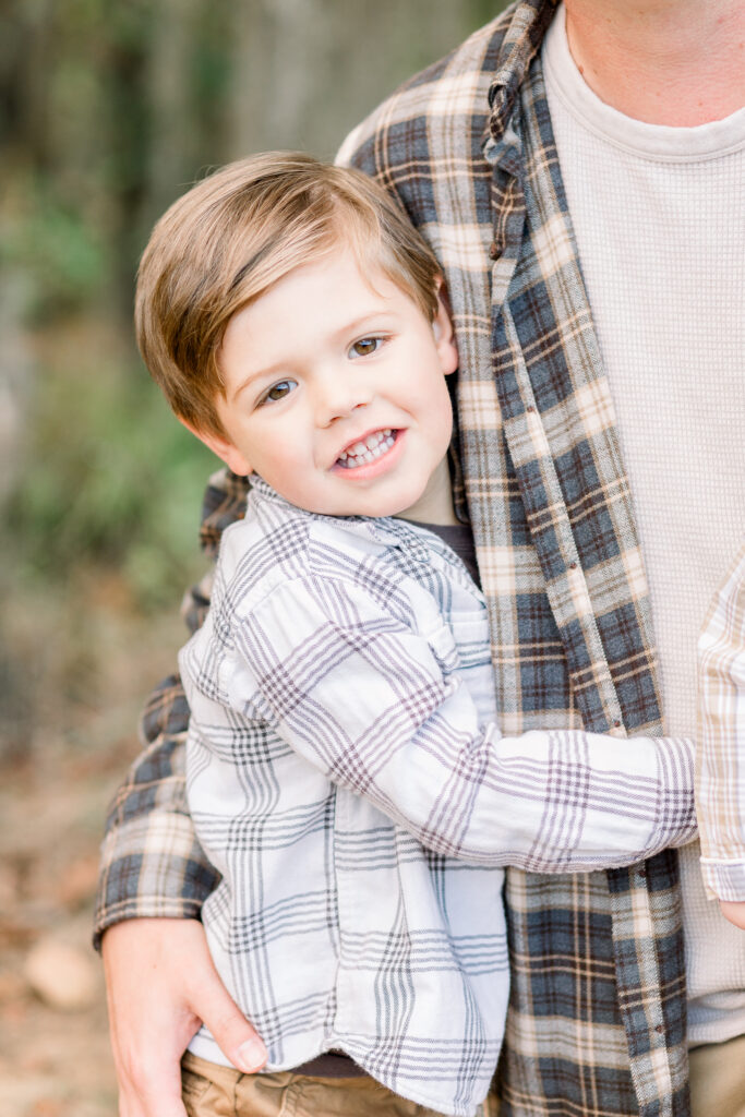 Little boy smiles at camera for fall family photos. Image captured by Flora, Mississippi photographer, CJ and Olive Photography. 