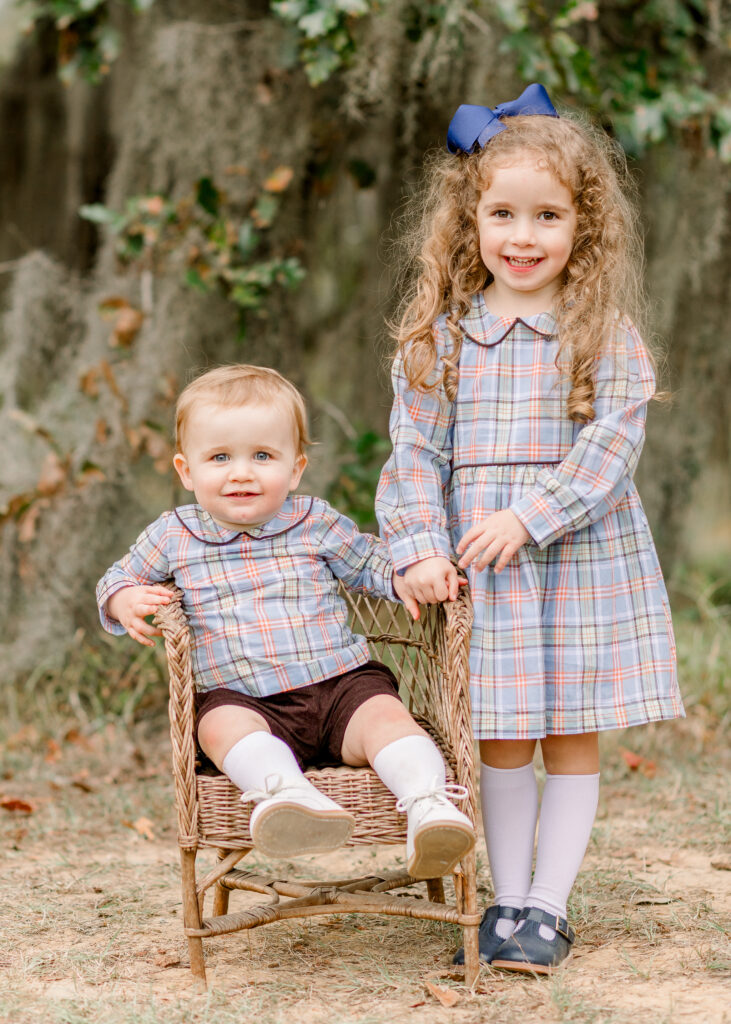 Brother and sister smile at camera for fall family photos at The Resting Place in Flora, MS. 