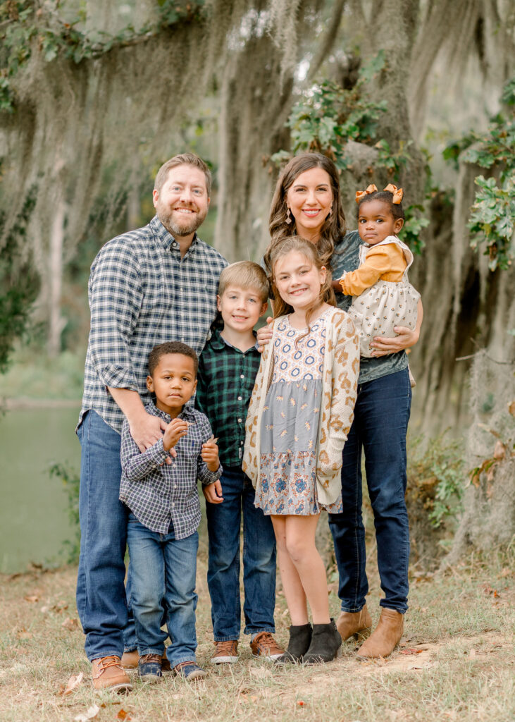 Family smiles together at camera for fall family photos at the Resting Place. Image captured by Mississippi family photographer, CJ and Olive Photography. 